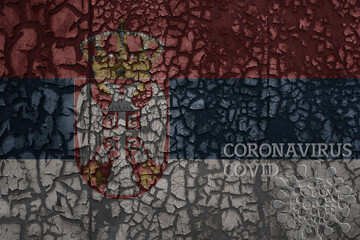 flag of serbia on a old metal rusty cracked wall with text coronavirus, covid, and virus picture.