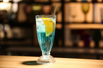 Glass of Blue Lagoon cocktail on table in bar