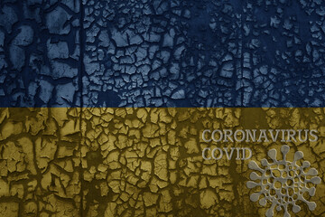 flag of ukraine on a old metal rusty cracked wall with text coronavirus, covid, and virus picture.
