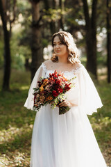 Obraz na płótnie Canvas girl in a wedding dress in the autumn forest