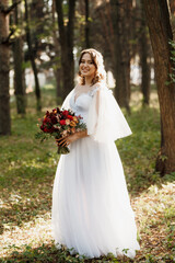 Fototapeta na wymiar girl in a wedding dress in the autumn forest