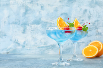 Glasses of Blue Lagoon cocktail on color background