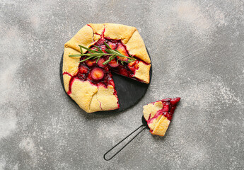 Composition with tasty plum galette on grunge background
