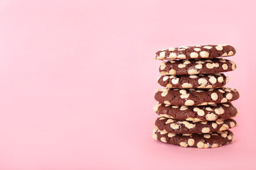 Stack of yummy cookies with white chocolate chips on color background