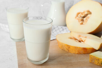 Glasses of tasty melon milkshake on light background, closeup