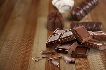 Composition of bars and pieces of different milk and dark chocolate on the desk