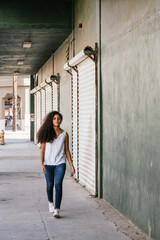 Woman teenage cuban girl walking through an alley in summer