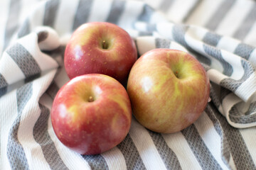 Three fuji apples on the tablecloth 