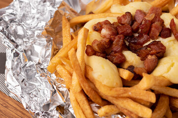 Portion of fries with cream cheese and diced bacon