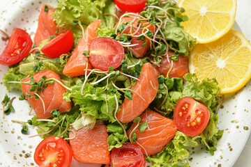 Tasty fresh salad with salmon in plate, closeup