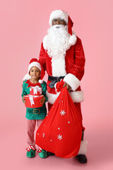 Cute little elf with Santa Claus and gifts on pink background