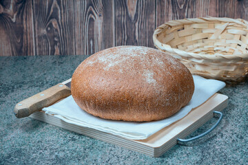 a round loaf of wheat bread with a baked shiny crust on the kitchen table