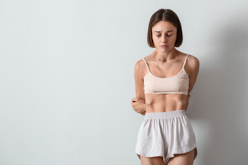 Obraz premium Young skinny woman on light background. Anorexia concept