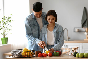 Young couple cooking in kitchen. Vegan Day