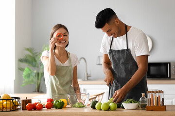 Young couple cooking in kitchen. Vegan Day