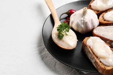 Plate of bread with lard spread on white background, closeup