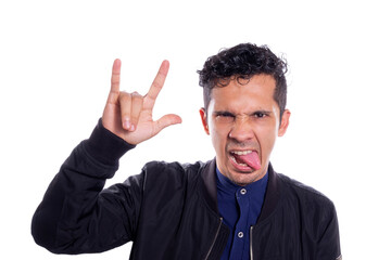 Man making rocker gesture, on white background. Young adult young man sticking out his tongue with...