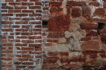 old stone crosse in red brick wall