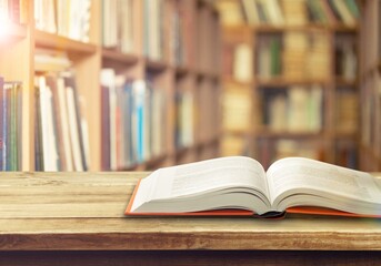 Open book on old wooden table in the library