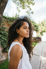 Portrait of a cuban teenage girl in a garden with walls full of green plants, closeup latin cuban teenage woman