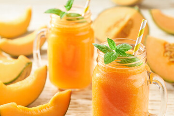 Melon smoothie in glasses with melon slices, selective focus.