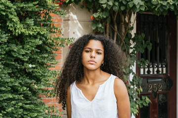 Portrait of a cuban teenage girl in a garden with walls full of green plants, closeup latin cuban teenage woman
