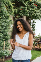 Portrait of a cuban teenage girl in a garden with walls full of green plants, closeup latin cuban teenage woman
