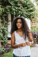 Portrait of a cuban teenage girl in a garden with walls full of green plants, closeup latin cuban teenage woman