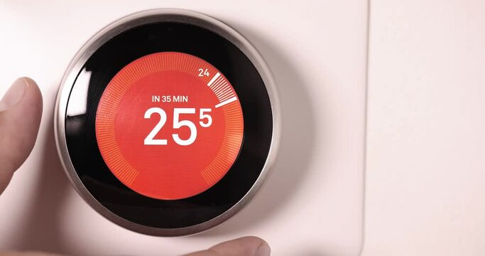 A person lowering the temperature on a Smart Thermostat on Celsios scale  in slow motion 