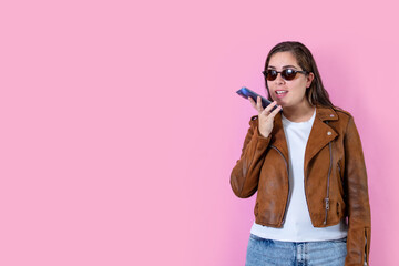 Woman in leather jacket recording her voice, leaving voice message.