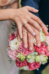 Obraz na płótnie Canvas Hands and rings on a wedding bouquet