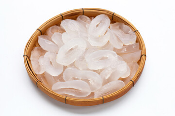 Toddy palm slices in round bamboo basket on white background.