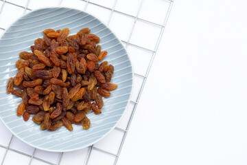 Dried grape raisins in plate on white background