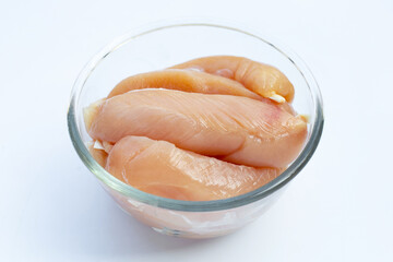 Raw chicken tenders in glass bowl on white background.
