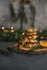 Oat homemade cookies on Christmas scenario, holy and dry orange.