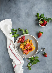 morning brunch with homemade french toast with fresh strawberries on grey background