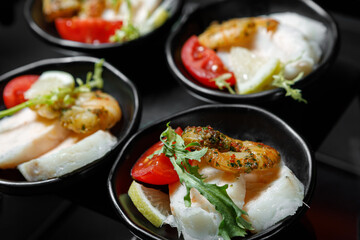 A light snack of shrimp, fish fillet, lemon, tomato and greens.