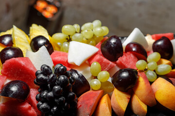 Grapes, sliced watermelon, melon, peaches close-up.