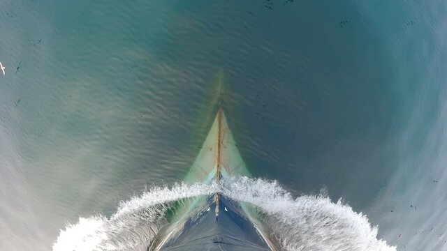 View from above. The bow of the ship is cut by the waves of the calm northern sea.