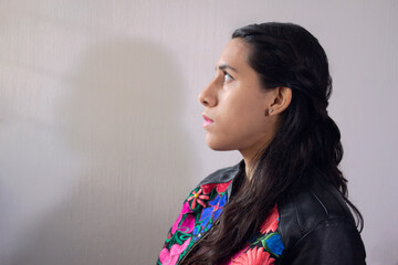 Mujer morena con chamarra de flores bordades