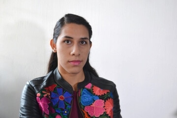 Mujer morena  de frente con chamarra de flores bordada