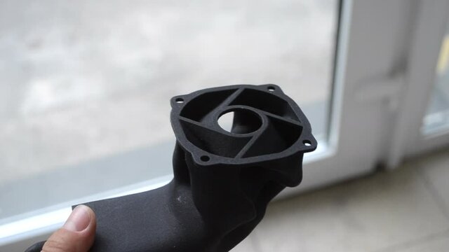 Man holding plastic model printed on powder 3d printer from polyamide powder.
