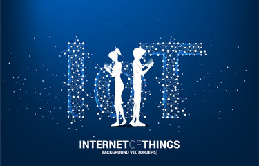 Silhouette of man and woman use mobile phone standing and Polygon dot connect line shaped IoT wording . Concept for telecommunication and internet of things.