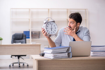 Young male employee in time management concept
