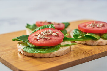 Rice cakes with Spinach and tomatoes on top. Healthy food.