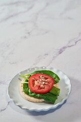 Healthy meal of rice cakes made with organic ingredients, spinach and tomato..