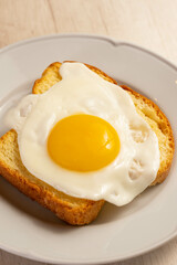 Fried egg above a toast.