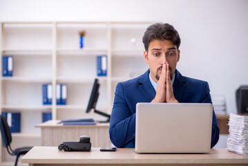 Young businessman employee and too much work in the office