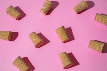Creative layout made of wine corks on pastel pink background. Flat lay, top view. Minimal abstract party and celebration concept. 