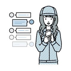 立ってスマートフォンで楽しくチャットで会話する作業員の女性